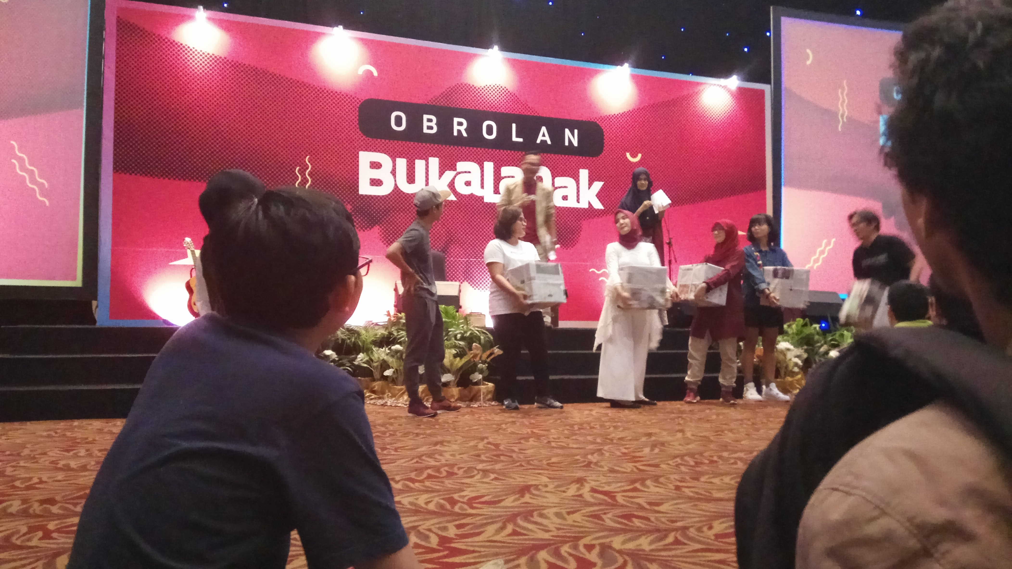 Mas Nug habis ketawa-ketawa lihat adegan di atas panggung. (Ekspresi wajah tidak terlihat, maafkan. Cuma berani foto dari belakang. Maklum anak baru 😂